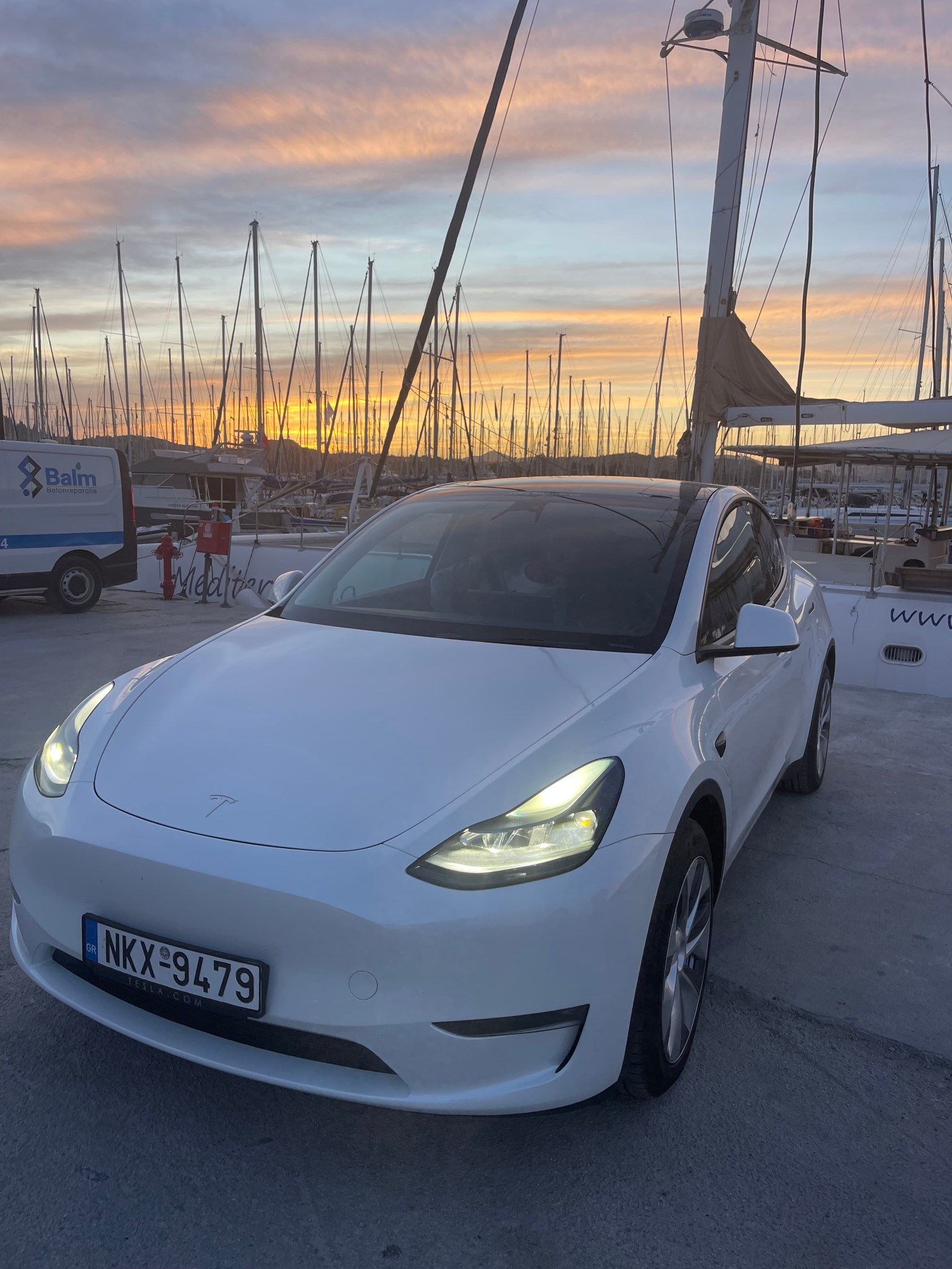 White Tesla Model Y at a marina
